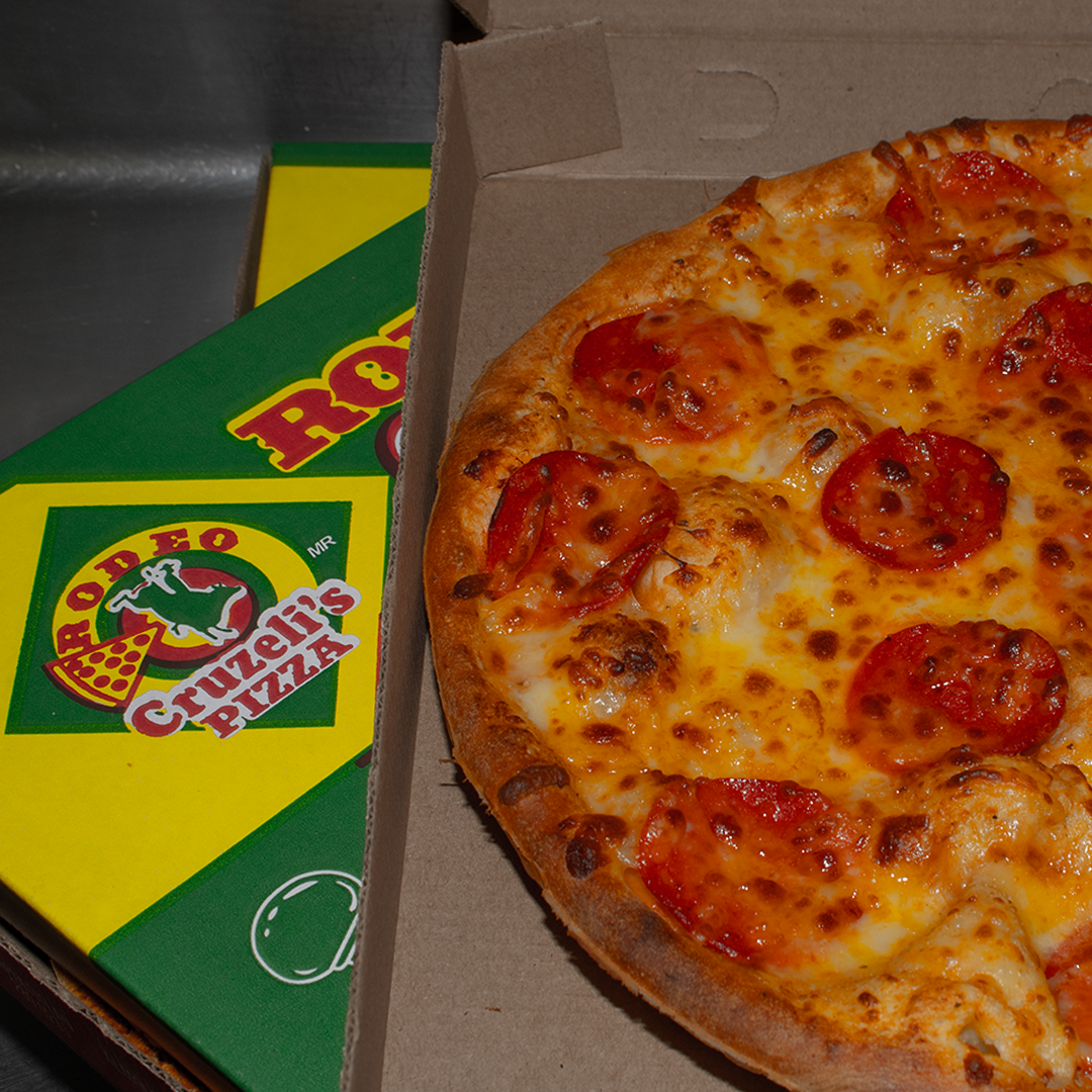 Pizza junto a cajas verdes y amarillas